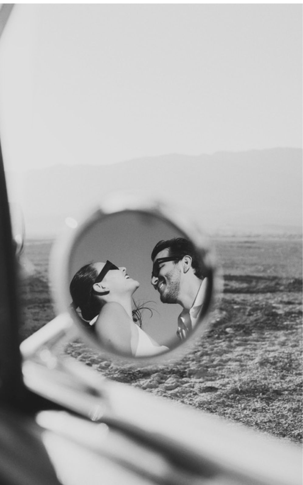 Bere y Renán reflejados en el espejo retrovisor de un auto en el desierto